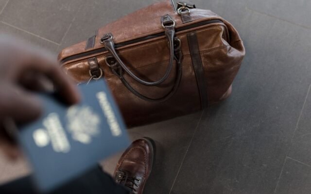 Brown leather bag with passport in an airport setting