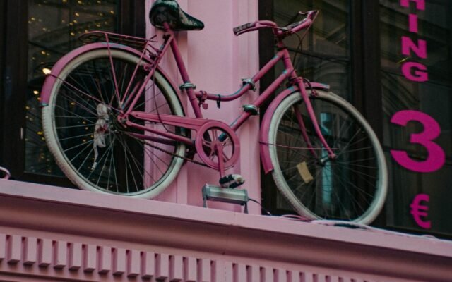 An eye-catching pink bicycle decorates a storefront facade
