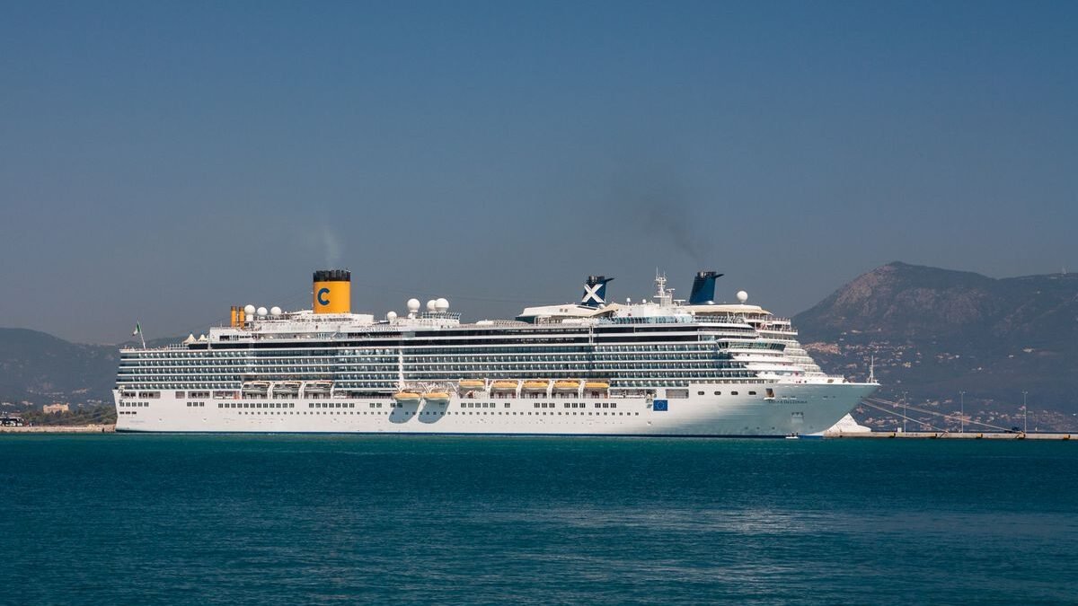 A majestic cruise ship sails near the scenic coastline of Corfu