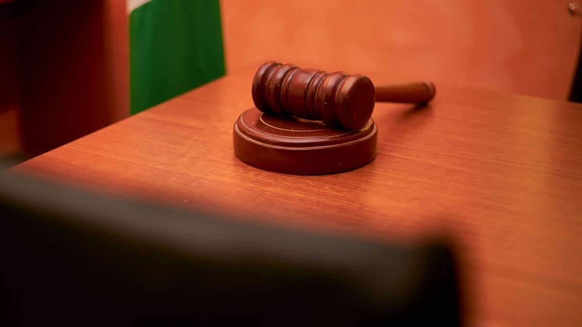 A close-up of a gavel on a courtroom desk representing law and justice