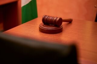 A close-up of a gavel on a courtroom desk representing law and justice