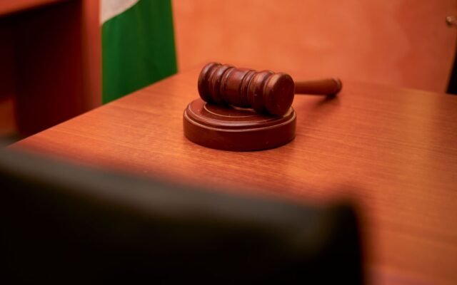 A close-up of a gavel on a courtroom desk representing law and justice