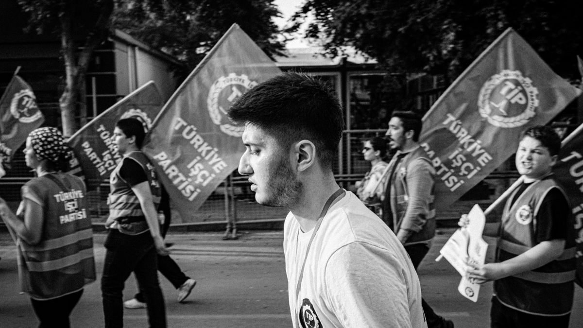 A black and white photo capturing a political demonstration with flag-waving participants