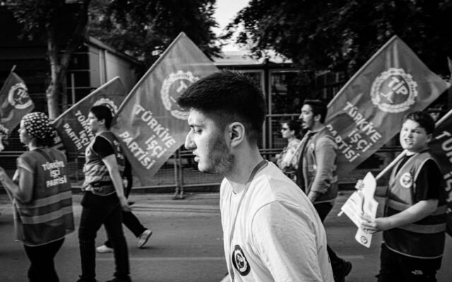 A black and white photo capturing a political demonstration with flag-waving participants