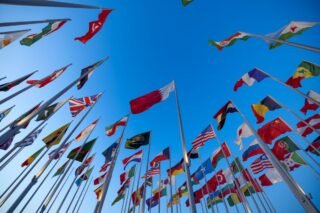 International flags waving against a clear blue sky in Doha
