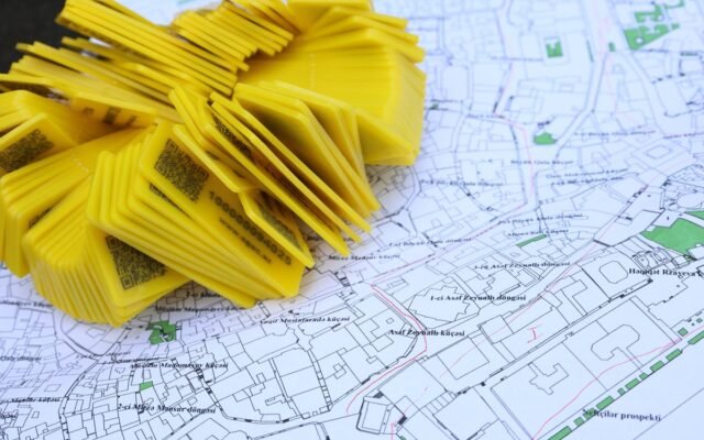 Stack of yellow QR code markers placed on a detailed map for location tracking and navigation