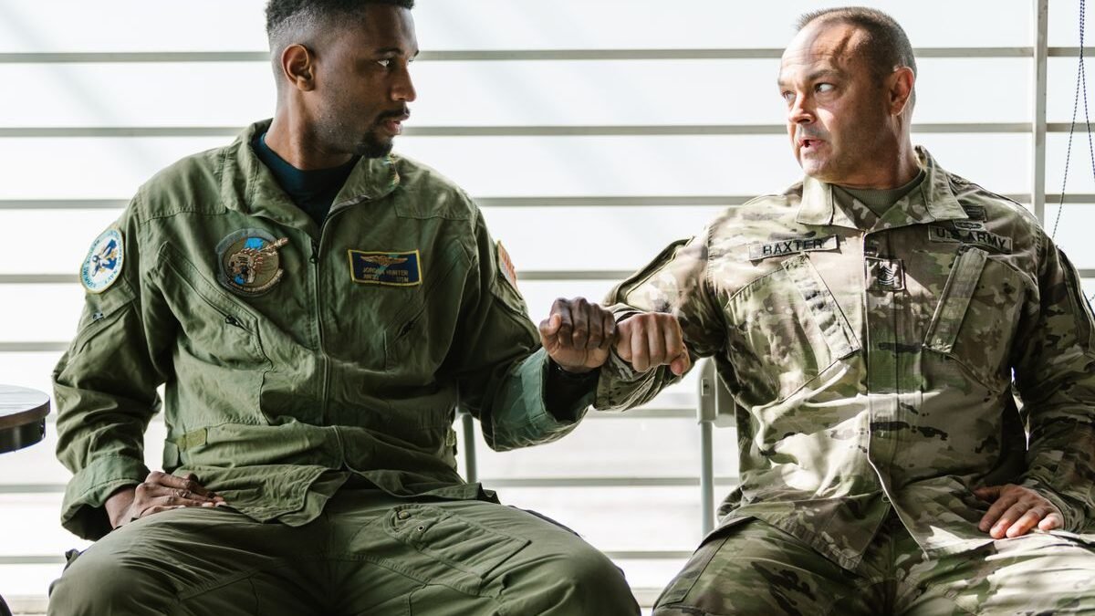Two US military men in uniform share a fist bump