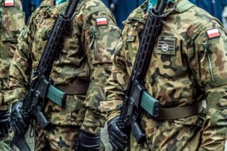 Polish soldiers in uniform standing in formation with rifles