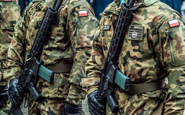 Polish soldiers in uniform standing in formation with rifles