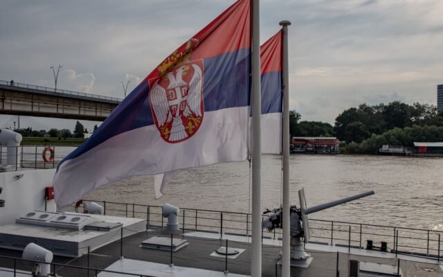 Serbian flag seen on a riverboat under a cloudy sky