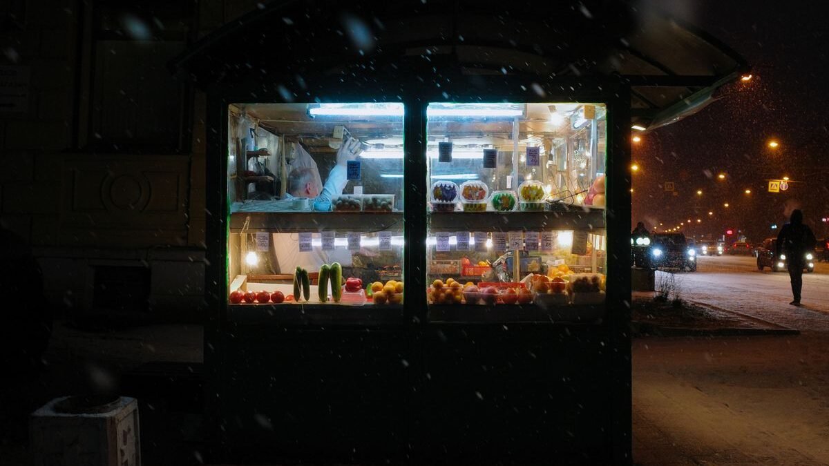 A cozy street kiosk illuminated at night