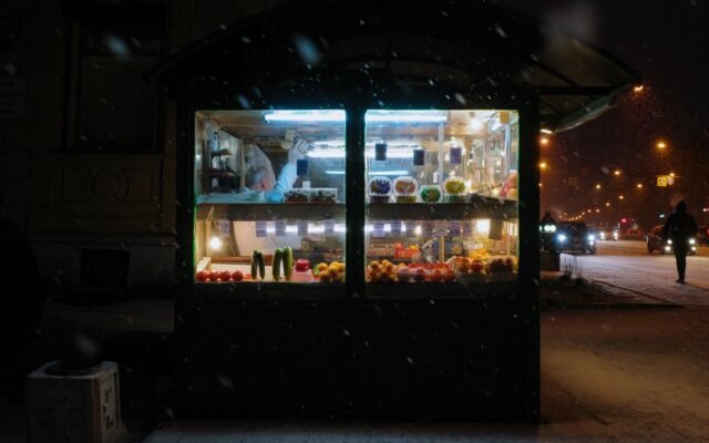 A cozy street kiosk illuminated at night